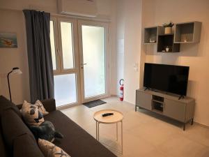 a living room with a couch and a flat screen tv at Casa al mare Teresa in Porto SantʼElpidio