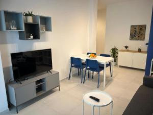 a living room with a table with chairs and a television at Casa al mare Teresa in Porto SantʼElpidio