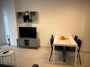 a living room with a table with chairs and a television at Casa al mare Teresa in Porto SantʼElpidio +29 photos
