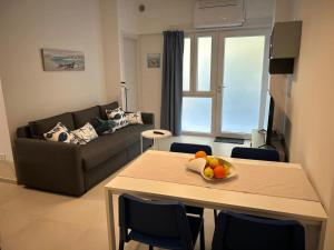 a living room with a table with a bowl of fruit on it at Casa al mare Teresa in Porto SantʼElpidio