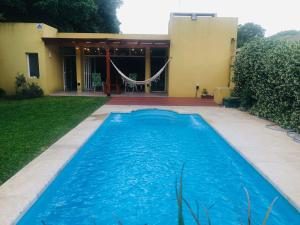 a swimming pool in front of a house at La quinta de los peques in Los Toldos