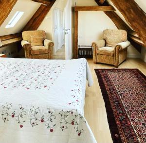 ein Schlafzimmer mit zwei Stühlen, einem Bett und einem Teppich in der Unterkunft The Old Brewery, 5 Seymour Buildings in Sherborne