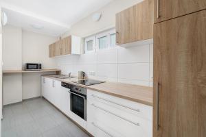 a kitchen with white appliances and wooden cabinets at Nad Šťastným sklepem in Valtice +5 photos