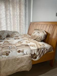 een ongeëvenaard bed met een houten hoofdeinde en kussens bij Kigali Beauty Homes in Kigali +27 foto's