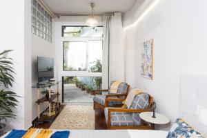 a living room with two chairs and a window at Rochinha Cozy Home in Funchal