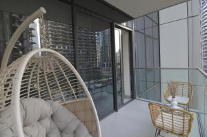 a room with a rattan chair on a balcony at Luxury 1BR Apt Best view Infinity Pool Burj Khalifa with Balcony in Dubai