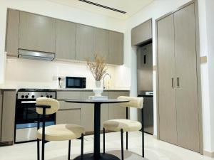 a kitchen with a table and two stools at Luxury 1BR Apt Best view Infinity Pool Burj Khalifa with Balcony in Dubai