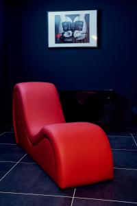 a red chair in a room with a blue wall at Love room évasion in Tuchan