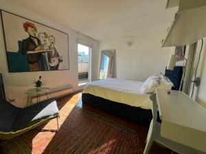 a bedroom with a bed and a chair and a window at Shoreditch Rooftop Suites in London