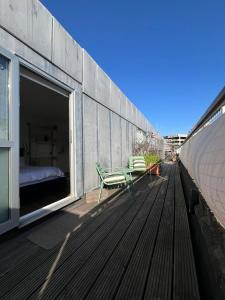 a balcony with a bed and a chair on a building at Shoreditch Rooftop Suites in London