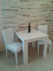 a white table with two chairs and a bottle of wine at Apartments and Rooms Jasna in Hvar