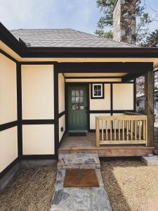 a small house with a green door and a porch at Storybook Cottage at Tudor Suites in Eureka Springs