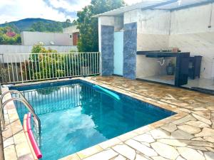 a swimming pool with blue water in a house at Casa Bela Vista in Capitólio