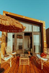 a patio with chairs and an umbrella and a table at Venti Beach Houses in Zandvoort