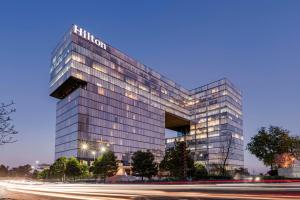 a tall glass building with a sign on it at Hilton Mexico City Santa Fe in Mexico City