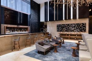 a lobby with a bar with stools and chairs at Hilton Mexico City Santa Fe in Mexico City