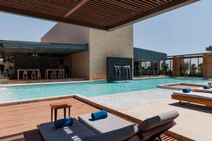 a swimming pool with chairs and a table in a building at Hilton Mexico City Santa Fe in Mexico City +73 photos