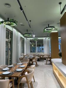 a restaurant with wooden tables and chairs and windows at Hotel Vila Misiri in Durrës