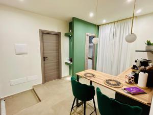a dining room with a table and green accents at EtnaLux in Paterno