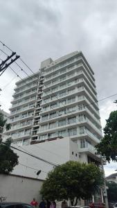 a large white building with people standing in front of it at Apartamento El Rodadero con balcón in Gaira