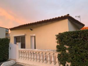 una casa con una recinzione bianca e un balcone di Maison Le Jean Bart a Cap d'Agde