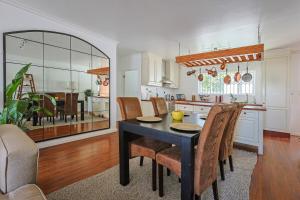 a kitchen and dining room with a table and chairs at Fully Equipped Claremont Home with Pool & Style in Cape Town
