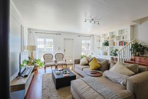 a living room with a couch and a table at Fully Equipped Claremont Home with Pool & Style in Cape Town