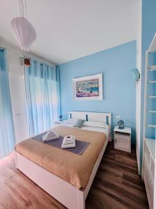 une chambre avec un grand lit aux murs bleus dans l'établissement Mimì Maison Bari, à Bari