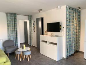 un soggiorno con TV e divano di Maison Le Jean Bart a Cap d'Agde