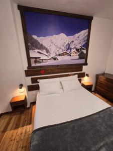 a bedroom with a large tv above a bed at Ca' Elide in Aosta