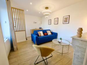 卡朗唐D-Day Suites的客厅里有一张蓝色的沙发和一张桌子