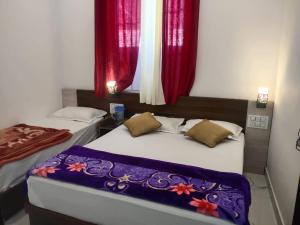 two beds in a room with red curtains at Hotel prisha pahal Home stay in Uttarkāshi