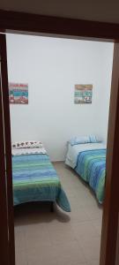 two beds in a room with a window at Rosa dei venti in Porto Empedocle