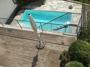 a white umbrella hanging on a house with a swimming pool at Casa La Solaria in Cannero Riviera