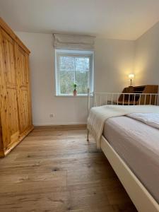 un dormitorio con una cama y una ventana en Villa Småland-Edles Naturidyll bei Berlin, en Glienicke
