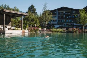 a person swimming in the water in front of a hotel at Neuhaus Zillertal Resort in Mayrhofen