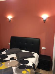 ボルドーにあるアパルトマン ボルドー サン ミッシェルの黒いベッドとオレンジ色の壁が備わるベッドルーム1室が備わります。