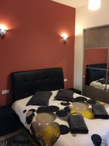 1 dormitorio con 1 cama con cabecero negro y espejo en Appartements Bordeaux Saint Michel, en Burdeos