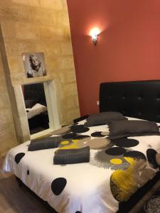 1 dormitorio con 1 cama con almohadas de color negro y amarillo en Appartements Bordeaux Saint Michel en Burdeos