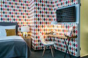 a bedroom with a bed and a desk with a chair at Roombach Hotel Budapest Center in Budapest