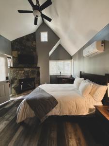 a bedroom with a large bed with a ceiling fan at Woodland Retreat at Tudor suites in Eureka Springs