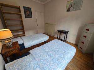 a room with three beds and a table with a lamp at Appartement spacieux en plein cœur de Brest in Brest +14 photos