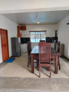 a kitchen with a table and chairs in a room at Thames Villa Galle in Hapugala