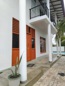 a building with orange doors and a balcony at Thames Villa Galle in Hapugala