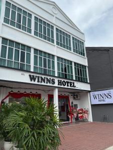 彭亨Winn's Hotel Bentong的一座白色的建筑,上面写着一家获奖酒店