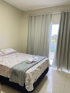 a bedroom with a bed and a large window at Casa de praia Duplex com Piscina Flecheiras in Trairi