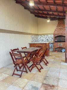 a wooden table and chairs in a room with a fireplace at Casa de praia Duplex com Piscina Flecheiras in Trairi
