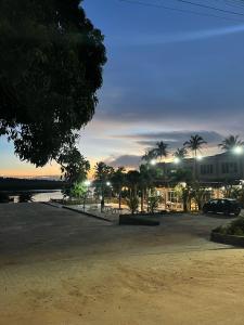 a parking lot with palm trees and a building at Casa de praia Duplex com Piscina Flecheiras in Trairi