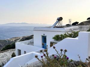 a white house with a view of the ocean at Sunny Stone Tinos House in Tinos