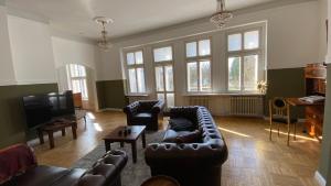 ein Wohnzimmer mit Ledersofas und einem Fernseher in der Unterkunft Schloss Badow in Badow
